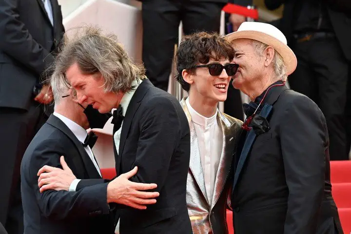 Wes Anderson es bienvenido por Frémaux en Cannes, junto a Timothée Chalamet y Bill Murray, en la premiere de "La crónica francesa". Foto  AFP