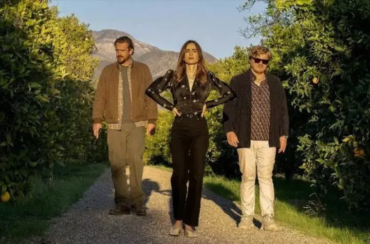 Los protagonistas caminan entre una plantación de naranjas que tiene el caserón donde transcurre la película. Foto Netflix