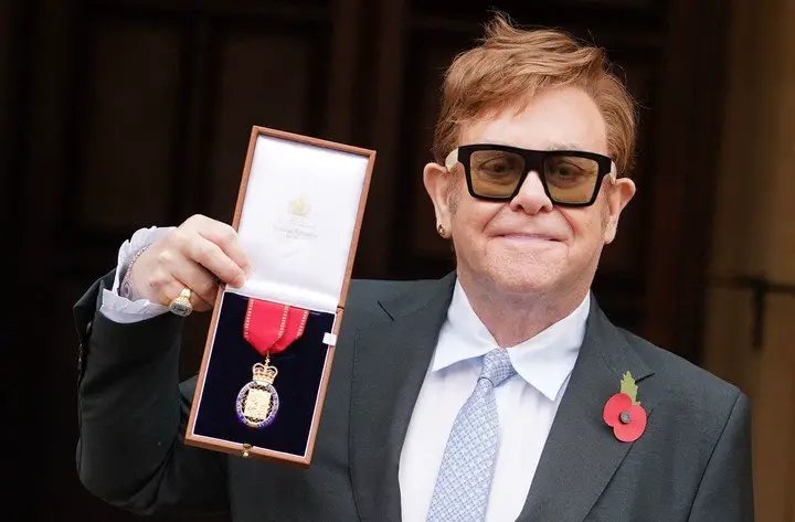 Elton John y su medalla de Miembro de la Orden de los Compañeros de Honor. Foto: AFP