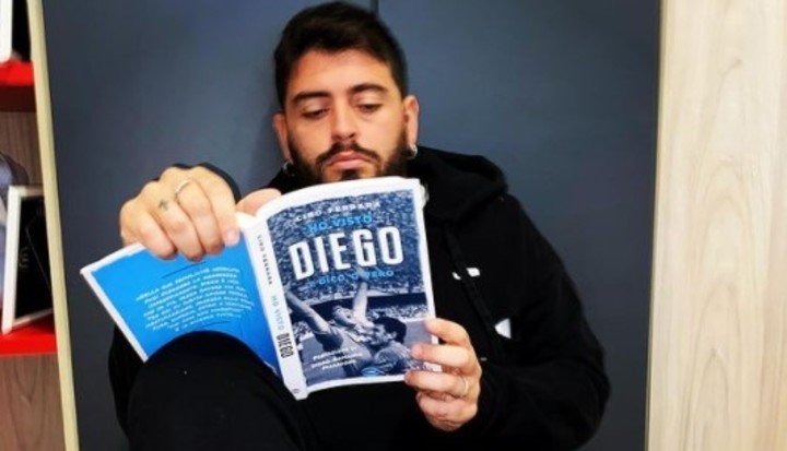Diego Armando Jr con un libro sobre su papá.