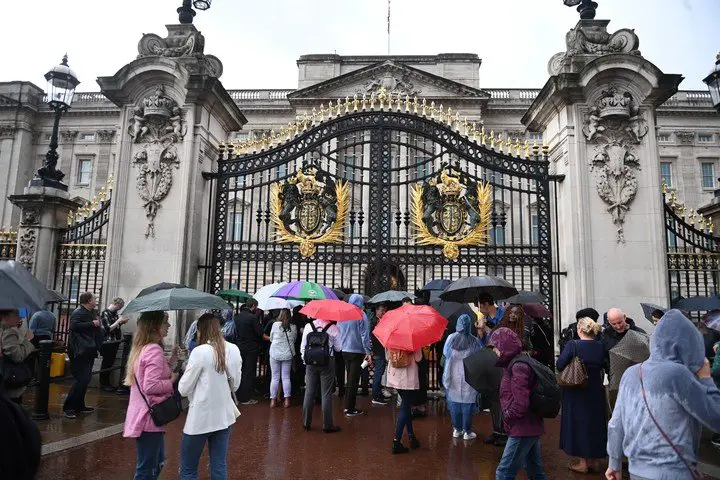 La entrada del palacio de Buckingham repleta de gente que esperaba noticias.