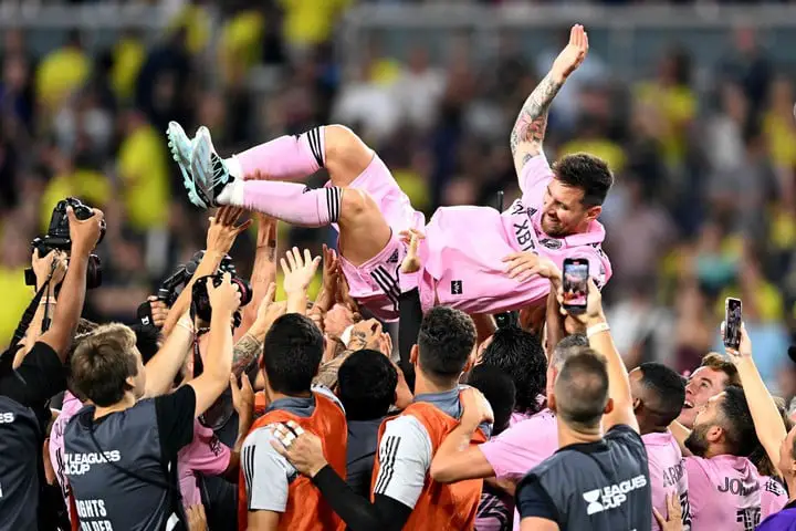 Messi levantado por sus compañeros después de la consagración (AFP).